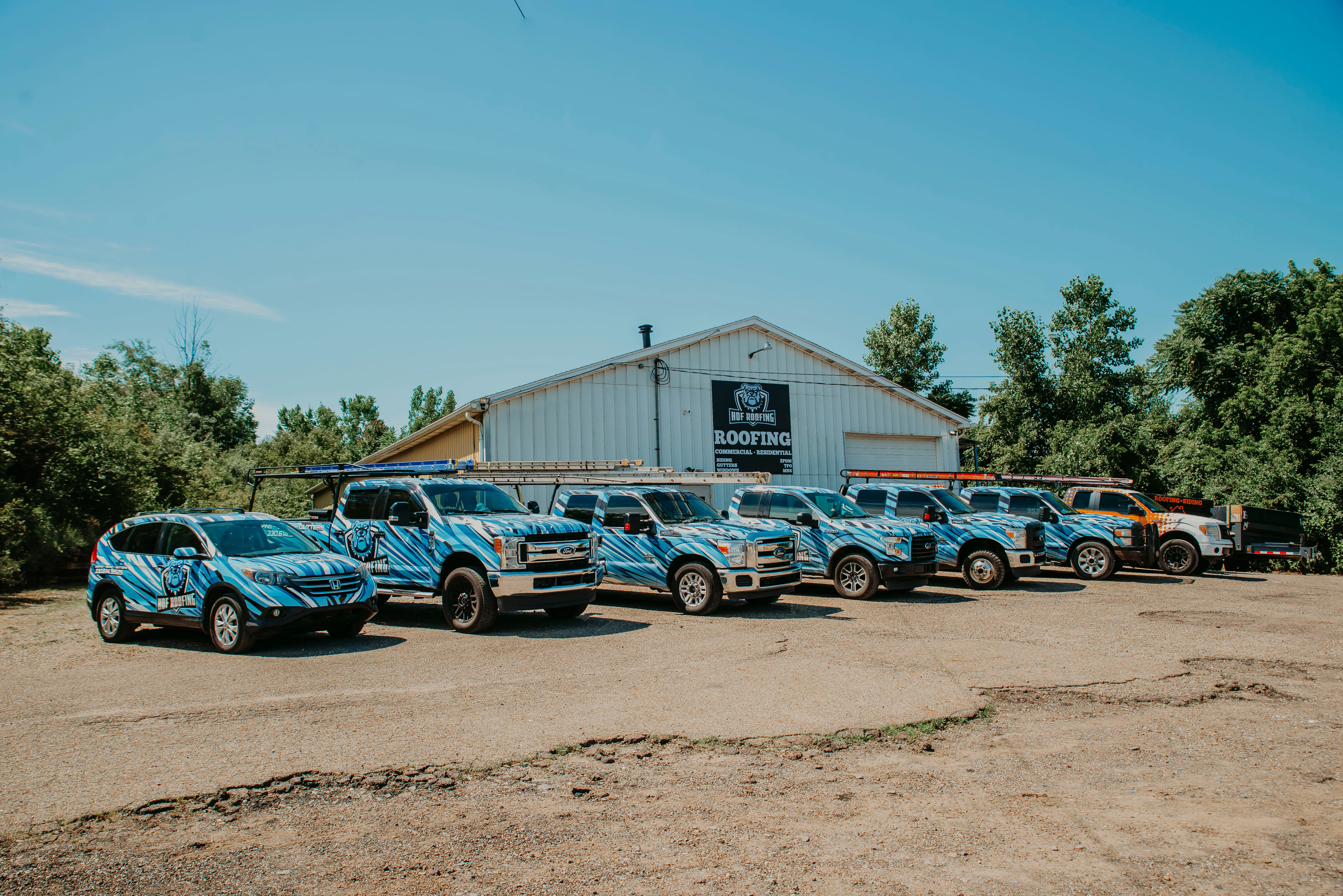 HOF Roofing commercial fleet outside a building in Northeast Ohio